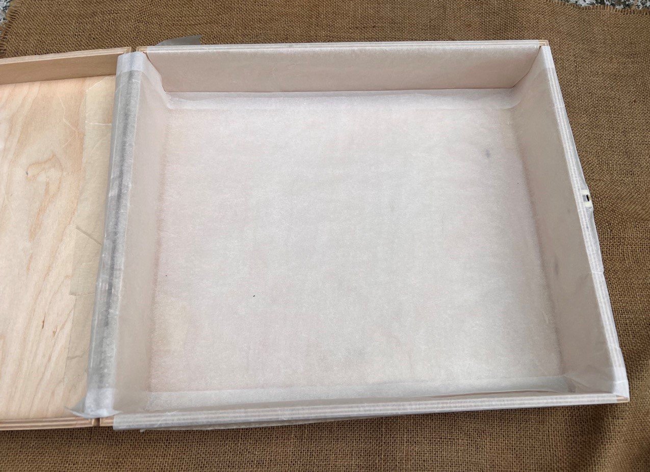Contenitore di legno rivestito in carta da forno come stampo del sapone